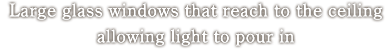 Large glass windows that reach to the ceiling allowing light to pour in.